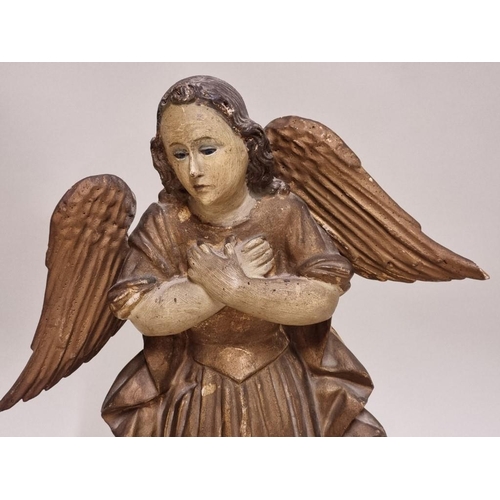 1595 - An antique carved and painted wooden angel, possibly South American, 30cm high.