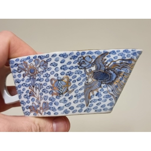 1630 - An interesting Chinese blue and white sauce boat, with gilt clobbered decoration, 11.5cm long.&... 