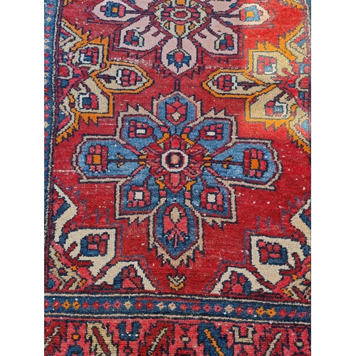 1085 - A Persian rug, having three floral central floral medallions, with geometric borders, 187 x 102.5cm.... 