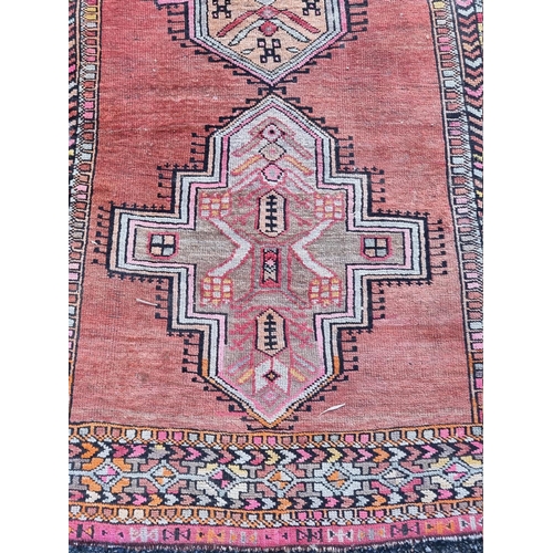 1095 - A Persian rug, having four central medallions, decorated with two small figures and geometric border... 