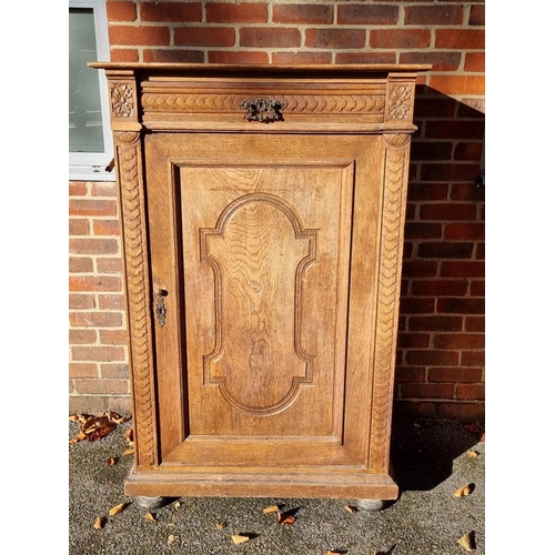 1157 - A Continental carved oak cupboard, 91cm wide. 