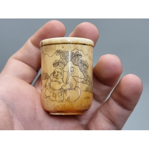 1673 - A Chinese horn libation cup, 10.5cm wide; together with a bone geegaw.