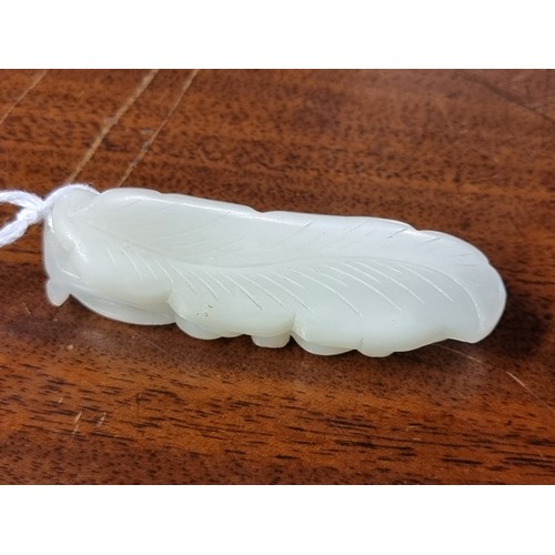 1657 - A good Chinese carved pale celadon jade beetle buckle, 5.7cm long; together with a Chinese carved pa... 