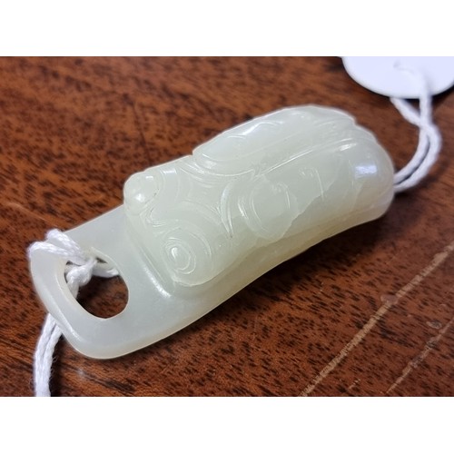 1657 - A good Chinese carved pale celadon jade beetle buckle, 5.7cm long; together with a Chinese carved pa... 