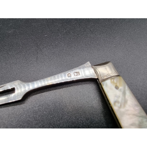 595 - A Georgian silver fruit fork, having mother of pearl mounts, 16cm extended.