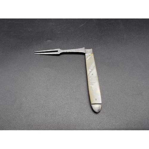 595 - A Georgian silver fruit fork, having mother of pearl mounts, 16cm extended.