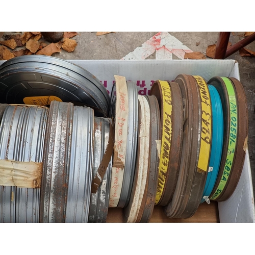 323 - FILM REELS: a large quantity of vintage film reels in metal tins, contained in 4 large boxes. (... 