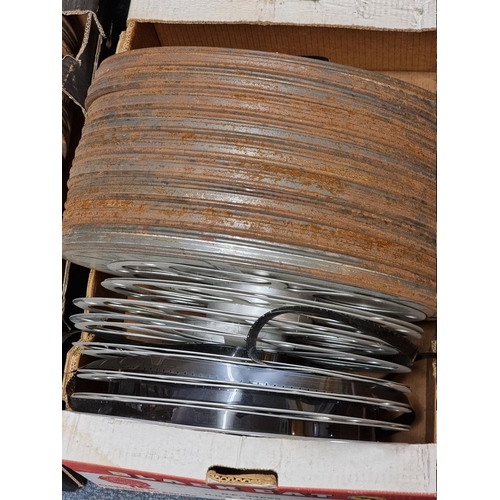 324 - FILM REELS: a large quantity of vintage film reels, many in metal tins, contained in 5 large boxes. ... 