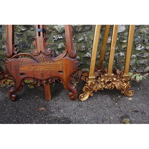 1049 - A gilt wood easel, 174cm; together with another carved example, 168cm high. (2)