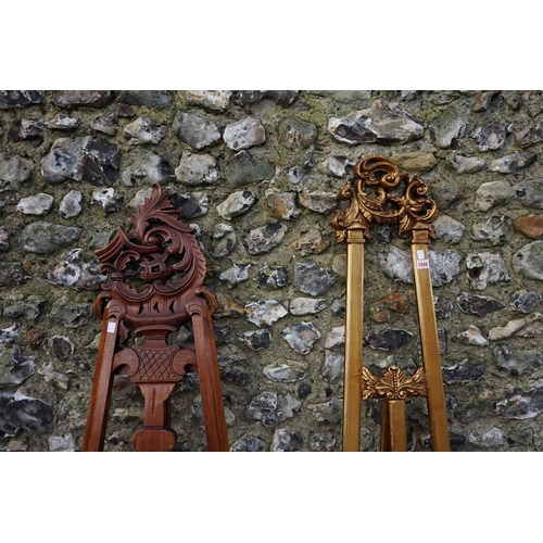 1049 - A gilt wood easel, 174cm; together with another carved example, 168cm high. (2)