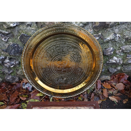 1052 - An eastern brass tray; together with a carved oriental footstool, with reversible top.... 