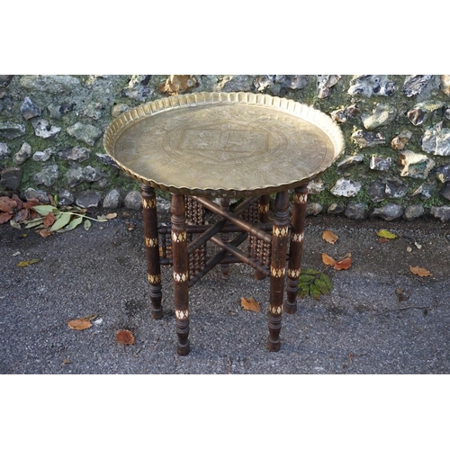 1058 - An Egyptian brass tray, on folding inlaid stand.