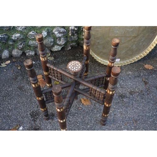 1058 - An Egyptian brass tray, on folding inlaid stand.