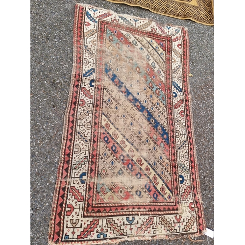 1076 - An old Persian rug, central field having repeated decoration, 141 x 88cm, (faded); together with a s... 