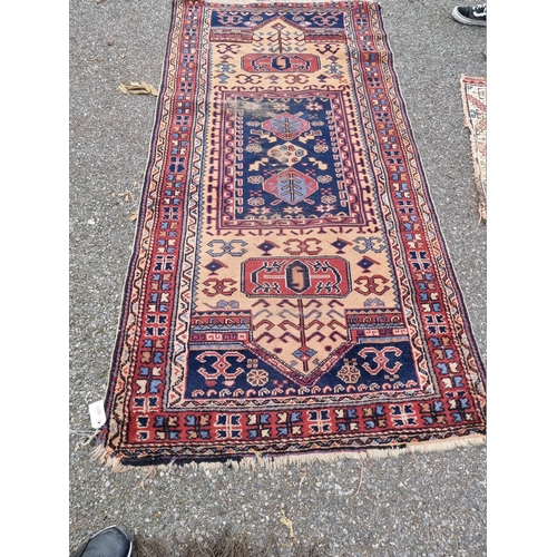 1077 - A Persian rug, central field decorated with trees and flowers, with geometric borders, 208 x 105cm.... 