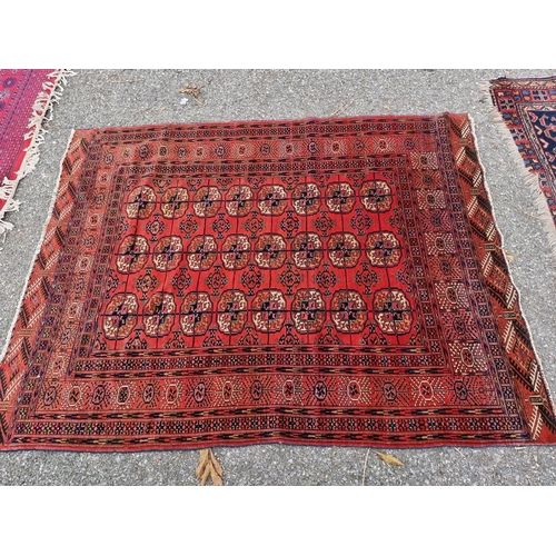 1078 - A Persian rug, having repeated design to central field, on a red ground, 167 x 128cm.... 