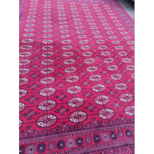 1080 - A large Bokhara carpet, on a red ground, 363 x 274cm.