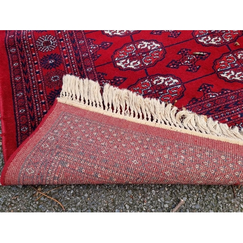 1080 - A large Bokhara carpet, on a red ground, 363 x 274cm.