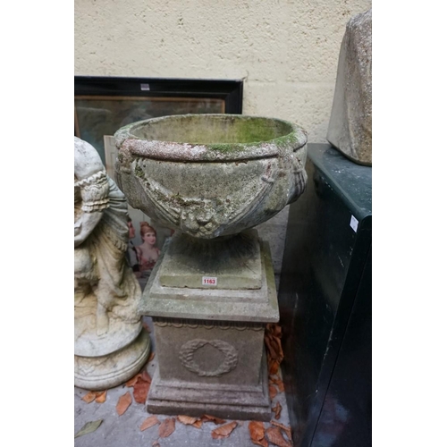 1163 - An old weathered composition stone urn and pedestal, 73cm high, (repaired chip to corner of base).... 