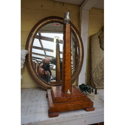 1200 - An Art Deco walnut table lamp, 37cm high; together with a copper fret frame oval easel back mirror, ... 