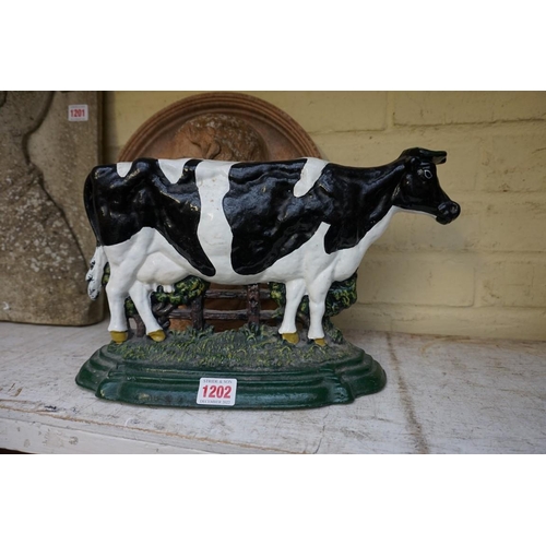 1202 - A painted cast iron cow doorstop, 36.5cm wide.