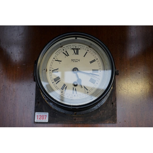 1207 - A World War II Smiths black painted eight day bulkhead timepiece, 18cm diameter.