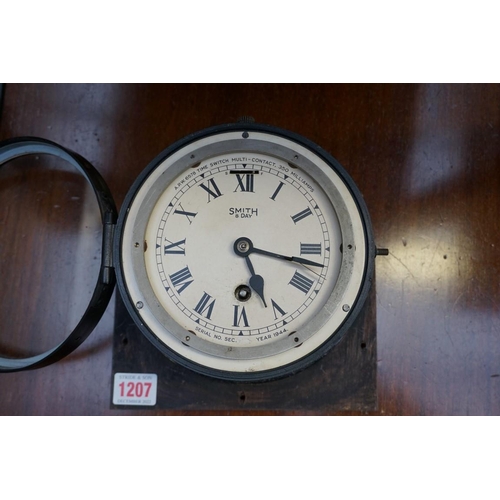 1207 - A World War II Smiths black painted eight day bulkhead timepiece, 18cm diameter.