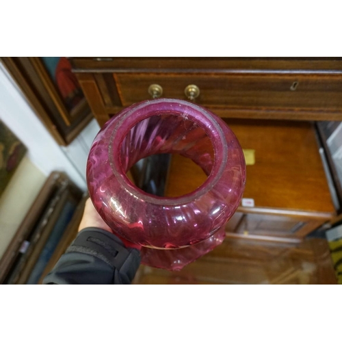 1296 - A Victorian brass oil lamp, with cranberry glass shade, height excluding chimney 48cm. ... 