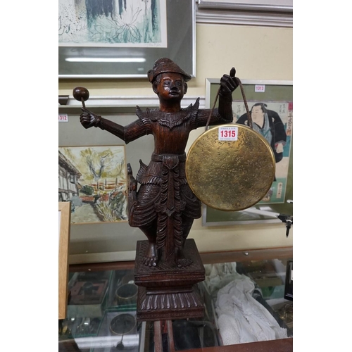 1315 - A Thai carved hardwood figural table gong, 57cm high. 