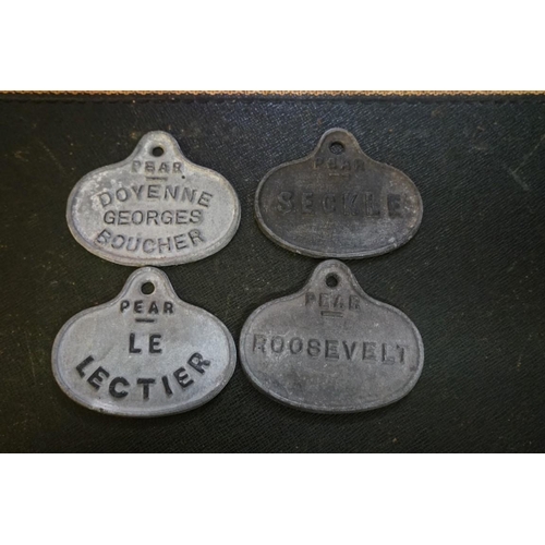 1319 - A mixed lot, to include a set of four antique galvanized pear tree labels; and a small silver trophy... 