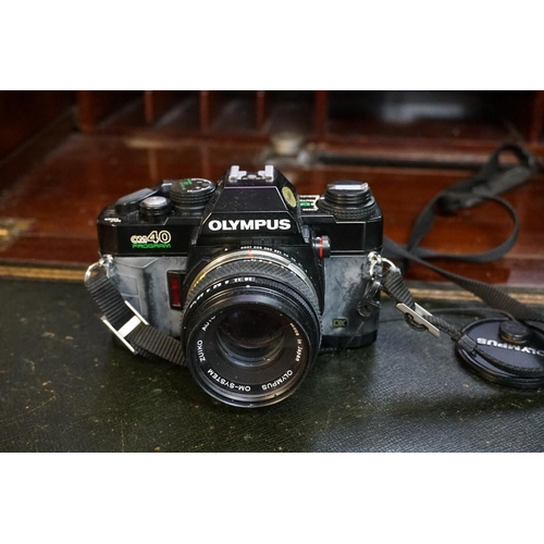 1336 - Cameras: an Olympus OM40 camera, with Olympus lens; together with another lens; a lens case and came... 