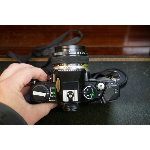 1336 - Cameras: an Olympus OM40 camera, with Olympus lens; together with another lens; a lens case and came... 