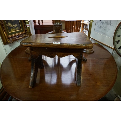 1347 - An antique elm milking stool, 34cm wide. 