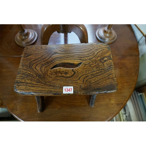 1347 - An antique elm milking stool, 34cm wide. 