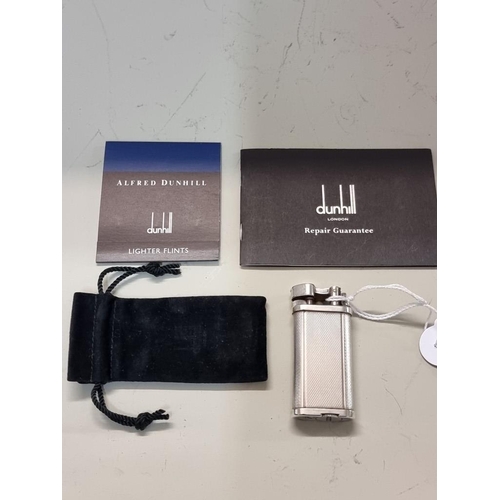 1667 - A Dunhill 'Unique' engine turned silver plated lighter, model UL 1301, with velvet drawstring bag, a... 