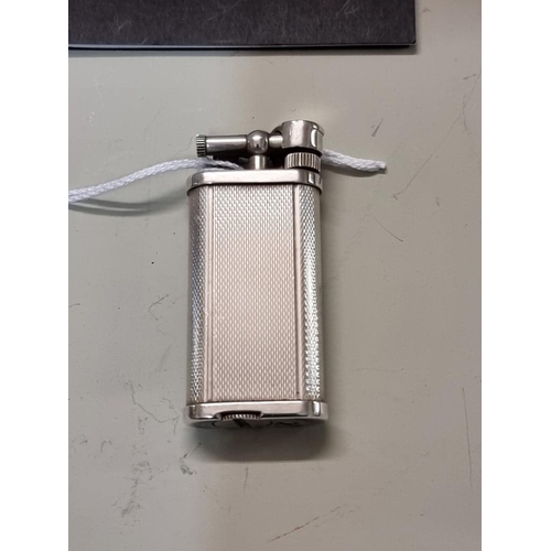 1667 - A Dunhill 'Unique' engine turned silver plated lighter, model UL 1301, with velvet drawstring bag, a... 