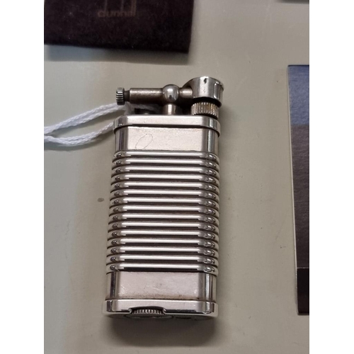 1668 - A Dunhill 'Unique' silver plated lighter, model UL 1324, with velvet drawstring bag, and repair guar... 