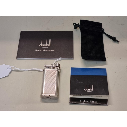 1669 - A Dunhill 'Unique' engine turned silver plated lighter, model UL 1301, with velvet drawstring bag, a... 