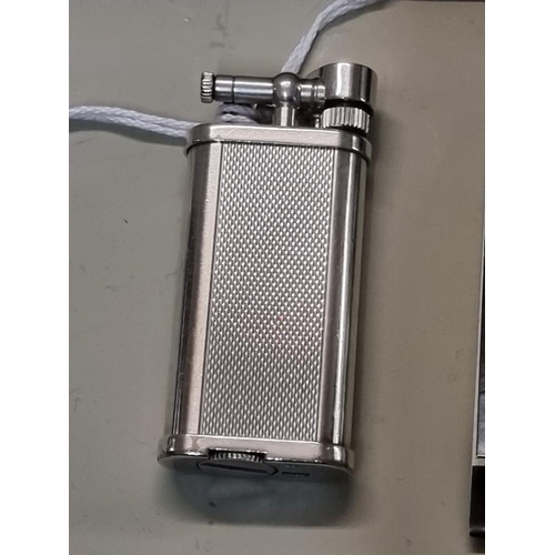 1669 - A Dunhill 'Unique' engine turned silver plated lighter, model UL 1301, with velvet drawstring bag, a... 