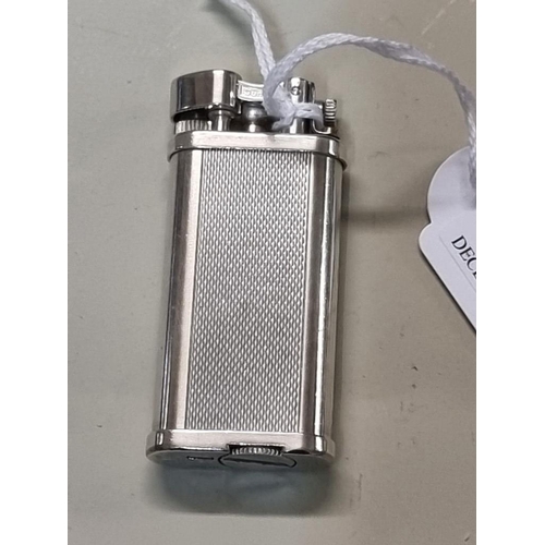 1669 - A Dunhill 'Unique' engine turned silver plated lighter, model UL 1301, with velvet drawstring bag, a... 