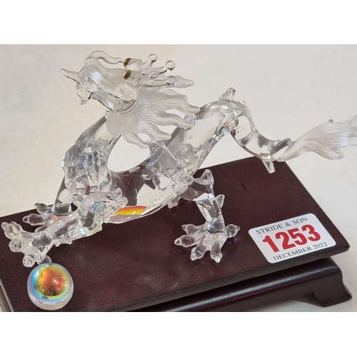 1253 - A Swarovski dragon, 15.5cm long, on wood stand. 