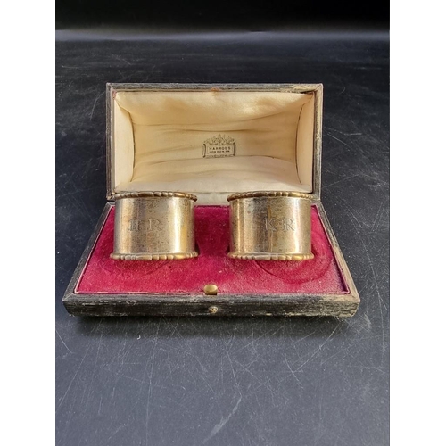 508 - A pair of silver napkin rings, by R W, London 1915, in Harrods case, 61g.