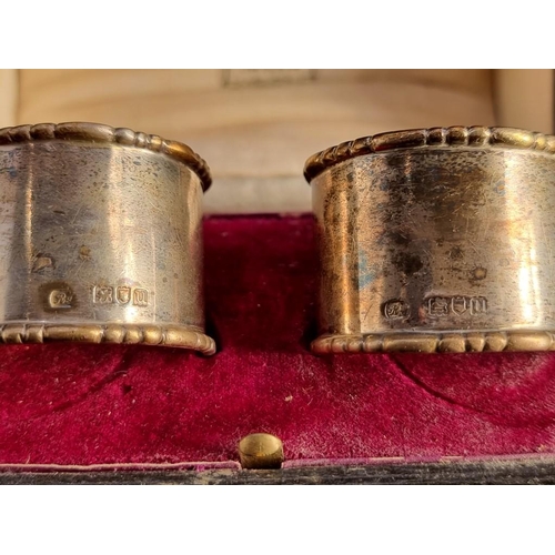 508 - A pair of silver napkin rings, by R W, London 1915, in Harrods case, 61g.