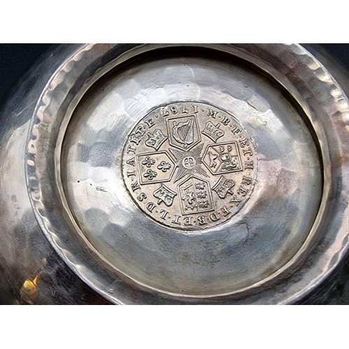 536 - A silver twin handled Quaich, having hammered decoration and inset George III 1785 silver shilling t... 