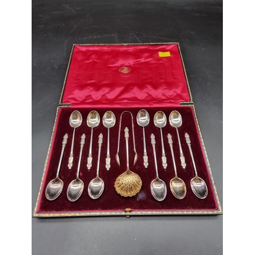 558 - A cased set of twelve EPNS apostle teaspoons, matching tongs and sugar sifter spoon, the case inscri... 