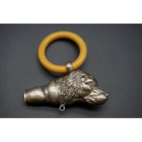 594 - A silver dog's head teething ring, (a.f.).