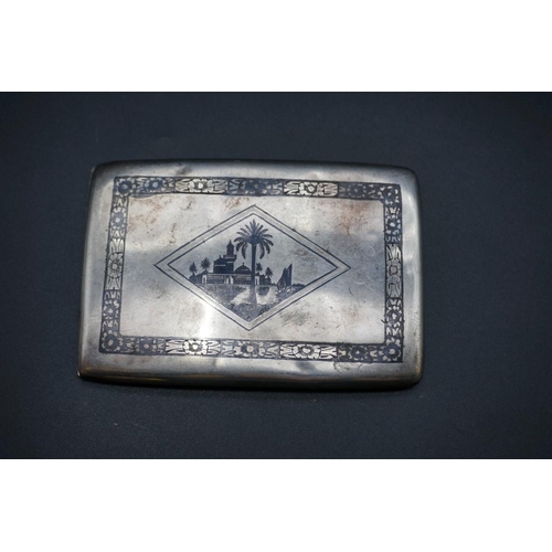 606 - An Egyptian niello cigarette case, 11.5cm; together with a child's silver teether. (2)... 