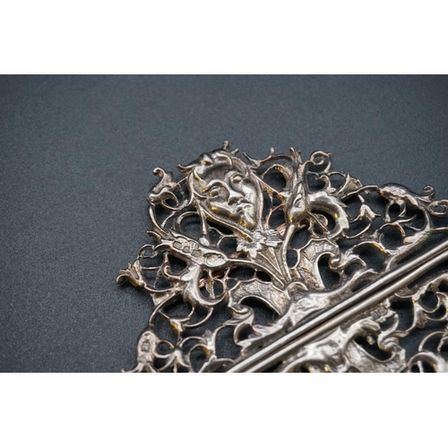 612 - An unusual Victorian silver nurse's belt buckle, decorated Devil's head amongst pierced floral decor... 