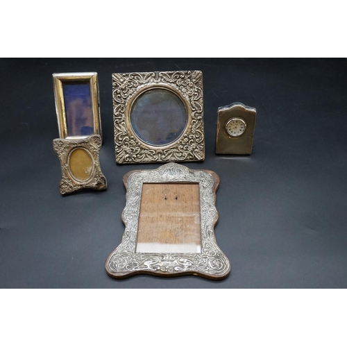 640 - Four silver photograph frames, largest 20 x 16.cm; together with a silver easel clock, by R Carr. (5... 