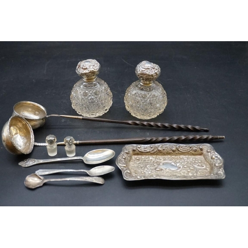 643 - A group of silver items, comprising; two silver lidded cut glass perfume bottles; two toddy ladles w... 